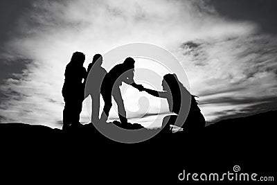 Silhouette of helping hand between two climber Stock Photo